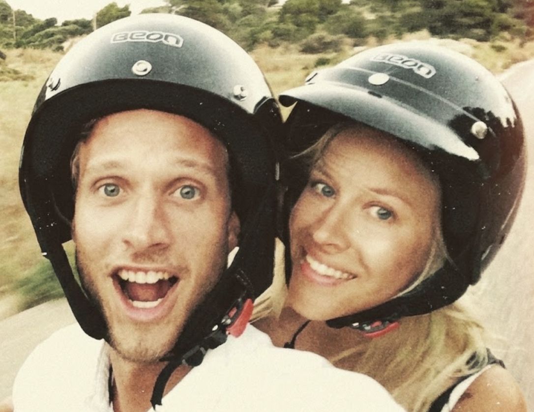 Lovisa och Mattias i hjälmar på en moped, skrattande mot kameran